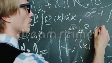 年轻<strong>数学家</strong>在黑板上用严肃的脸书写公式